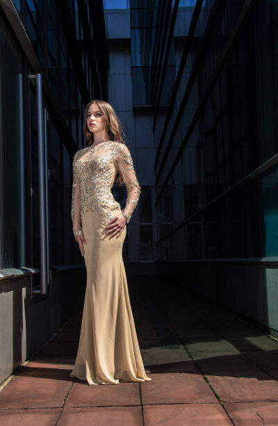 Beautiful, fashionable girl in dress in front of modern building